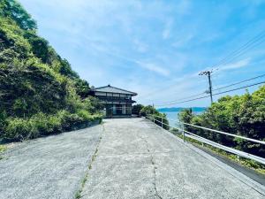 a road leading to a building on a hill at ぽつんとオーシャンビューでバーベキューも出来る1日1組貸切宿カゴヤブハウス in Otsuki