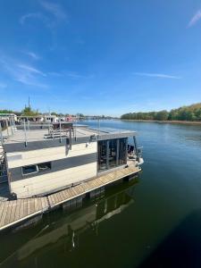 a dock with a boat on the water at Domy na wodzie- Dziwnów in Dziwnów