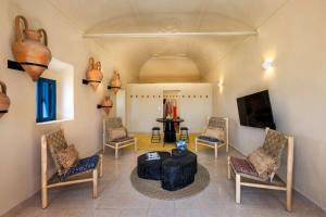 a living room with chairs and a table and a tv at Amphora Aelia Gem - Akrotiri Seaview Getaway in Akrotiri +22 photos