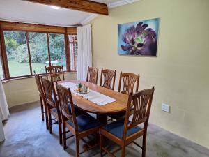 a dining room with a wooden table and chairs at L Chiam Self-Catering Cottage in Winterton