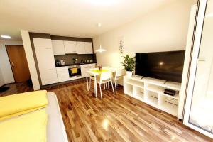 a living room with a kitchen and a dining room table at Top2 Apartmenthaus Sonnenschein in Dornbirn