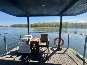 a boat deck with a table and chairs on the water at Domy na wodzie- Dziwnów in Dziwnów +47 photos