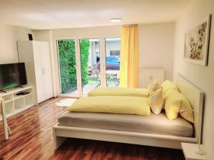 a bedroom with a large bed with yellow sheets at Apartmenthaus Sonnenschein in Dornbirn