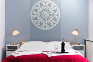 a bed with a bottle of wine and two glasses at Cilantro Bed & Breakfast in Wrocław