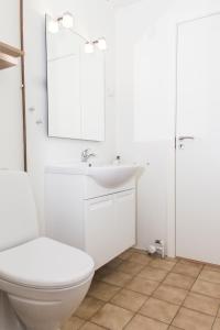 a white bathroom with a toilet and a sink at Give Apartment in Billund