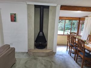 a fireplace in a living room with a table and chairs at L Chiam Self-Catering Cottage in Winterton