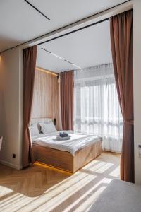 une chambre avec un lit et une grande fenêtre dans l'établissement GlowNest Apartment Near Mega, à Almaty