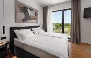 Un dormitorio con una gran cama blanca con ventana. en Villa Karbula, en Poreč