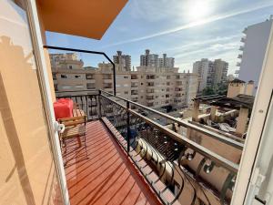 a balcony with a chair and a view of a city at Cozy Apartment close to the center in Torremolinos +4 photos