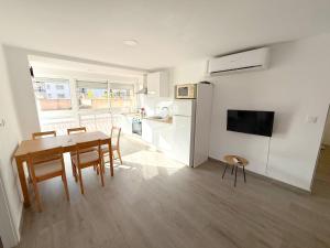 a kitchen and dining room with a table and a refrigerator at Cozy Apartment close to the center in Torremolinos