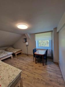a room with a table and a bed and a window at Pokoje pracownicze przy DK 51 in Lidzbark Warmiński