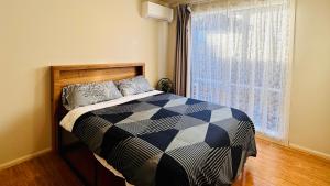 una camera da letto con un letto e una finestra di 20 minutes to Mel CBD 2 BRs AirCon unit guest house a Laverton