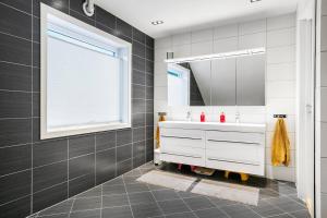 a bathroom with a white sink and a mirror at 6 Bedroom House in Ålesund +13 photos