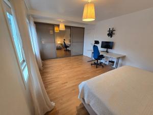 a bedroom with a bed and a desk with a computer at 6 Bedroom House in Ålesund