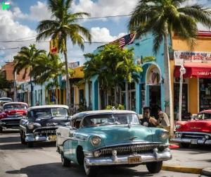 un groupe de vieilles voitures roulant dans une rue de la ville dans l'établissement Master Bedroom In CALLE OCHO, à Miami