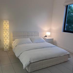 une chambre avec un grand lit et une fenêtre dans l'établissement Master Bedroom In CALLE OCHO, à Miami