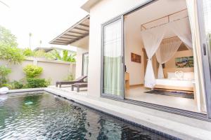 a villa with a swimming pool and a bedroom at Honeymooner Pool Villa@Seastone in Bang Tao Beach