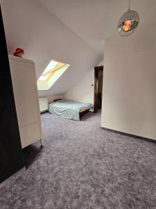 a attic room with a bed and a skylight at Apartamenty Boszkowo Wczasowa in Boszkowo