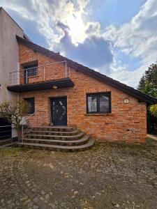a brick house with a black door and stairs at Apartamenty Boszkowo Wczasowa in Boszkowo