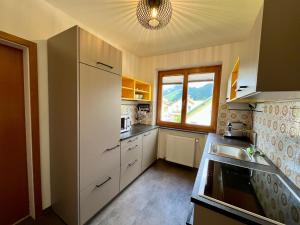 a kitchen with white cabinets and a large window at Salzkammergut Hideaway RUDOLPH in Bad Ischl +29 photos