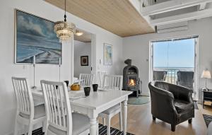 a dining room with a white table and chairs and a fireplace at Apartment Klint Strandvej Nykøbing Sj Vi in Højby
