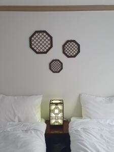 釜山LibeStay的一间卧室，墙上有两张床和一只钟