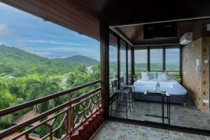 a bedroom with a bed and a balcony at Nestay in Karnāla
