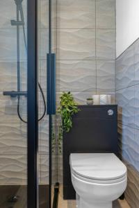 a bathroom with a toilet with a plant next to it at Modern Home Near To Airport Free Parking & Wifi in Uphall +35 photos