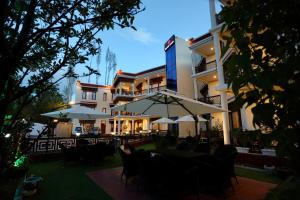 a hotel with tables and chairs and umbrellas at Hotel Nalanda Ladakh in Leh