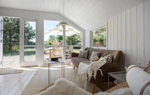 a living room with a couch and a table at Stunning Home In Sjællands Odde in Yderby