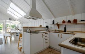 a kitchen with white cabinets and a sink at Stunning Home In Sjællands Odde in Yderby