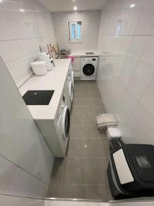 a white kitchen with a washer and dryer at SRR Stay in Gwangmyeong