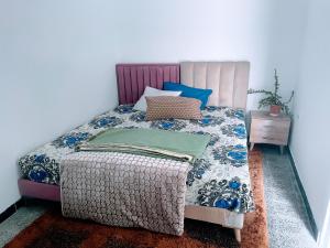ein Schlafzimmer mit einem Bett mit einer blau-weißen Bettdecke in der Unterkunft Maison Bleue in La Goulette