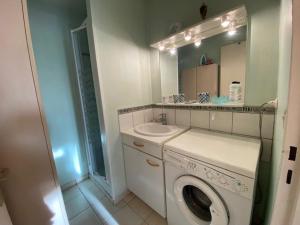 a bathroom with a washing machine and a sink at Appartement 3 pièces proche de la plage avec parking - FR-1-494-146 in Royan
