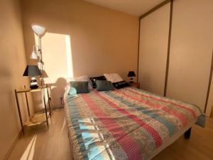 a bedroom with a bed with a colorful comforter at Appartement 3 pièces proche de la plage avec parking - FR-1-494-146 in Royan