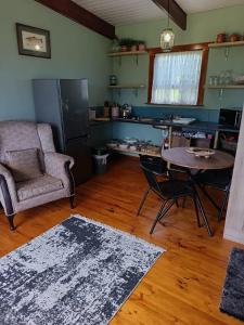 ein Wohnzimmer mit einem Tisch und einem Stuhl in der Unterkunft Sage Cottage in Wildernis