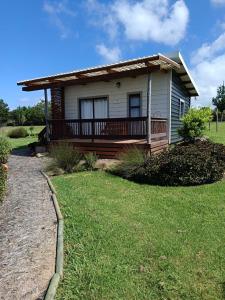 ein Haus mit einer Veranda und einem Rasenplatz in der Unterkunft Sage Cottage in Wildernis