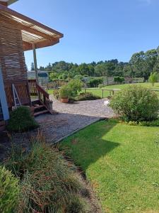eine Holzbank unter einem Pavillon in einem Park in der Unterkunft Sage Cottage in Wildernis