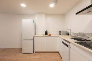 a white refrigerator in a kitchen with white cabinets at Doce de Colón Requena in Requena