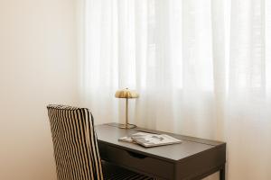 a desk with a lamp and a chair next to a curtain at Doce de Colón Requena in Requena