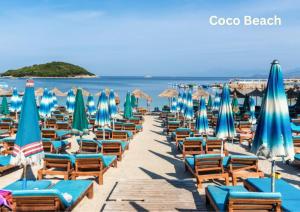 a bunch of chairs and umbrellas on a beach at Mihasi Apartments in Ksamil