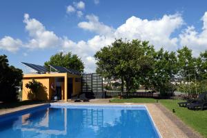 a swimming pool in a yard with a house at Casa Do Carvalho in Viatodos