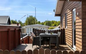 a patio with a table and chairs on a deck at Amazing Home In Otterup in Otterup