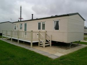 a large white mobile home with a porch at Eastgate Richmond 8 Berth Blow Heated Free WIFI in Ingoldmells