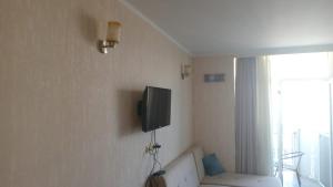 a living room with a couch and a tv on the wall at Sea Star 2 in Batumi