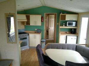 a small kitchen with a couch and a table at Eastgate Richmond 8 Berth Blow Heated Free WIFI in Ingoldmells