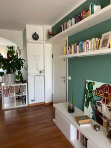 a living room with a table and shelves with books at Casa Mia Sirolo in Sirolo