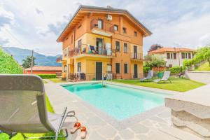 a villa with a swimming pool in front of a house at Sweet Caroline in Lierna