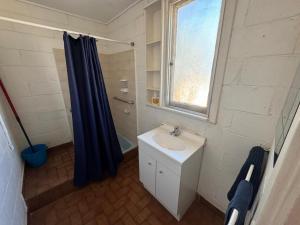 卡那封Pelican Point Waterfront Resort的浴室设有水槽和蓝色的浴帘 更多56张照片