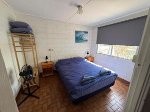 卡那封Pelican Point Waterfront Resort的一间卧室配有一张带蓝色床单和梯子的床